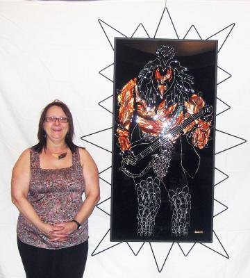 Jewelry artist Ginette Henri shows off one of her creations featuring a likeness of KISS bassist Gene Simmons, who recently visited Moncton.