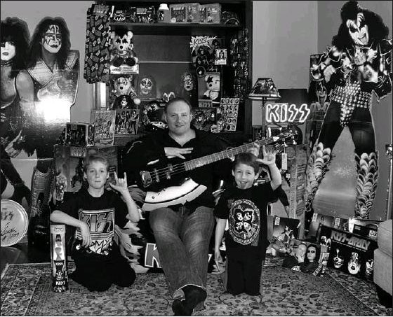 Dale Kemp, a KISS fan with a huge memorabilia collection, poses with his children Alex Kemp (left) and Dylan Kemp (right).  Dale will take his children to see KISS perform live in Fort McMurrary July 2 so they can learn what his collection was all about.