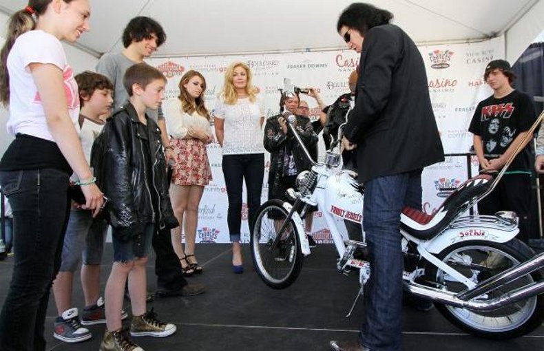 
Sophia Harrington, left, Gavin O'Driscoll, Thomas Haywood (leather jacket) and Tony Harrington (far right) of the Angels, Chopper and Bicycle Club present Kiss frontman Gene Simmons, Shannon Tweed, and their children Nicholas and Sophie with a bike they made for them at the View Royal Casino.